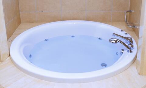 White Round Bathtub Filled Halfway With Water