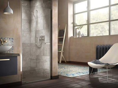 Matki Radiance frameless pivot shower door with exposed chrome shower in a rustic pink-plastered bathroom