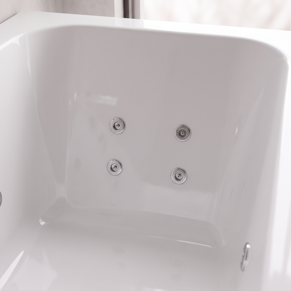 Close-up of four chrome whirlpool jets in a 2 x 2 group on the end wall of the white acrylic bath