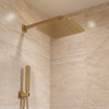 Brushed brass square rain shower head and wall-mounted handset