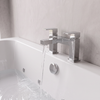 Chrome Slade two-pillar bath filler tap filling the whirlpool bath, with chrome overflow below
