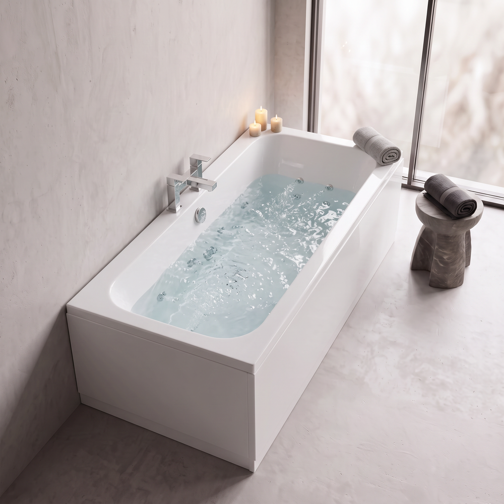 Double ended whirlpool bath filled with water and the chrome jets running, with candles