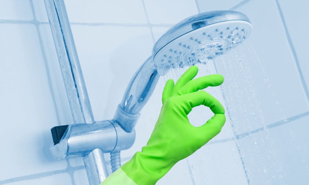 Image-of-Hand-In-Green-Gloves-Next-To shower-Enclsoure