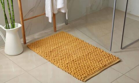 Brown Bath Mats On The Floor In Front Of Shower Enclosure