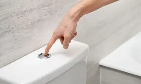 Man Hand Pressing The Toilet Flush Button