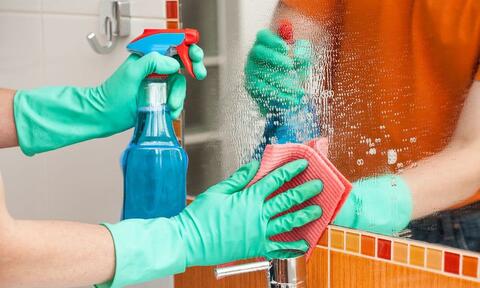 Man Hands Cleaning A Bathroom Mirror By Using Sprayer Filled With Rain-X Liquid