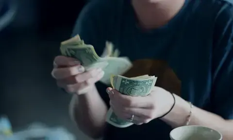 Woman With Navy Tee Holds Money