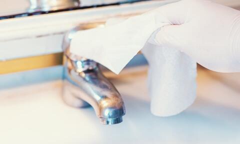 Bathroom Tap Being Cleaned By Using A Wet Wipe