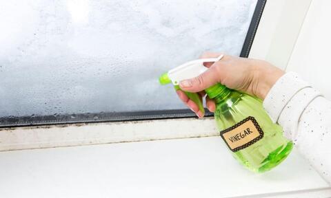 Women Hand Spraying Vinegar To Clean Bathroom Mirror