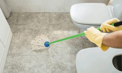Man Deep Cleaning Bathroom Floor Tiles Using Mop